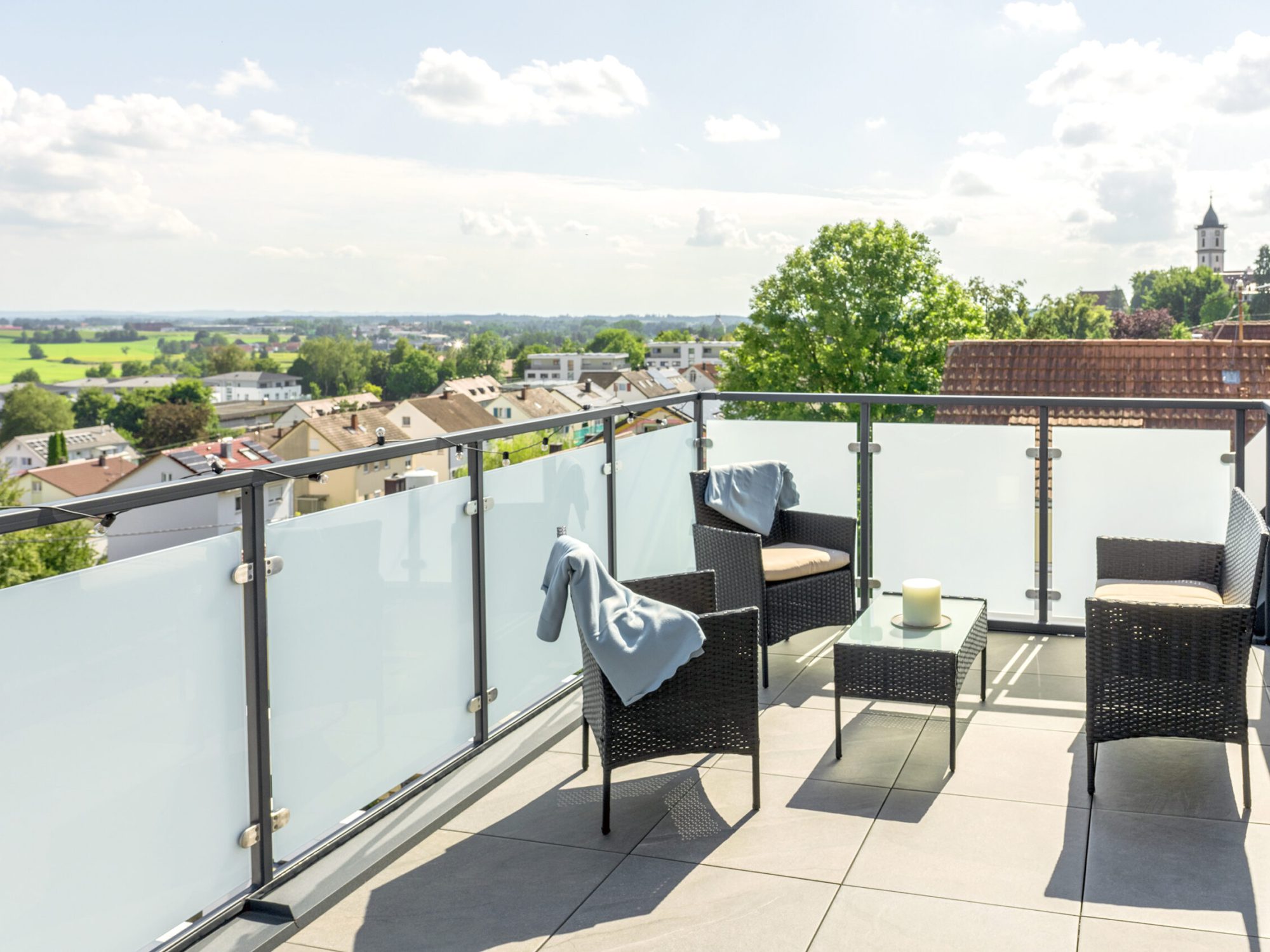 Dachterrasse mit Terrassenmöbel mit Aussicht auf Dächer und Himmel